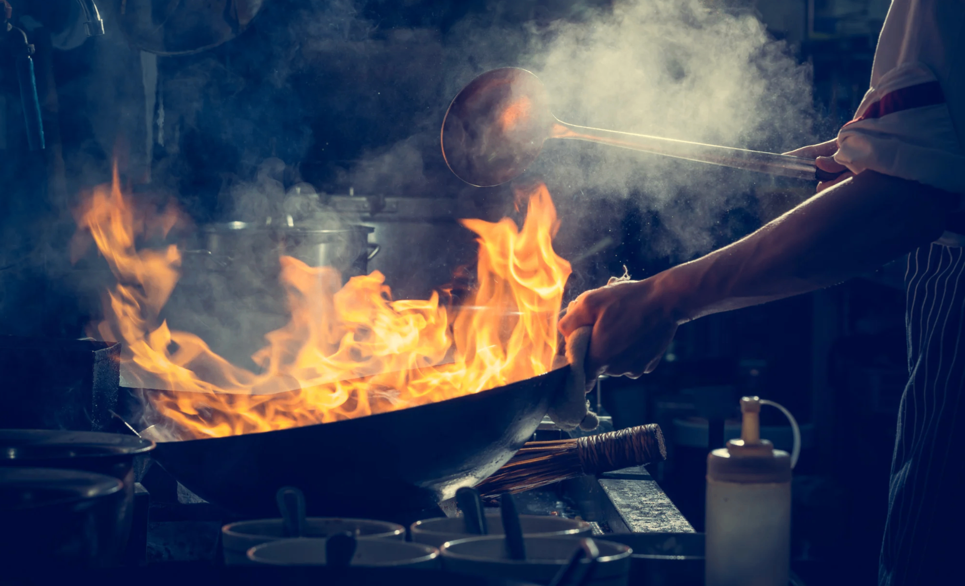 Chef cooking with flames in a professional kitchen